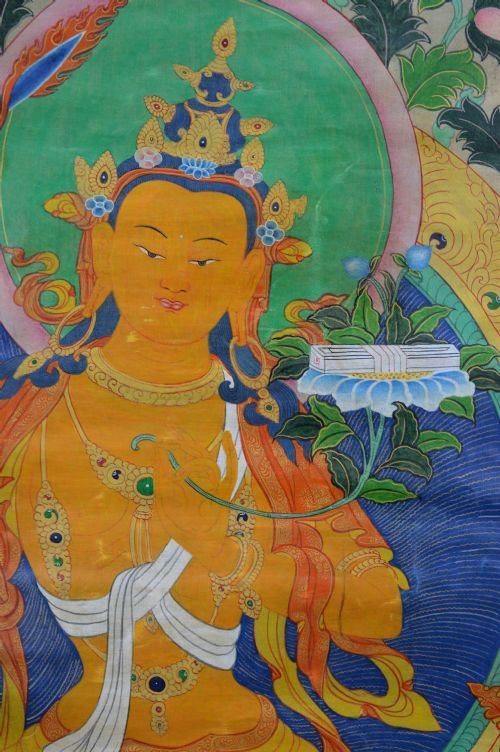 A Tibetan Thangka scroll depicting the seated deity Manjushri holding a raised sword and lotus stem, framed with a patterned silk border. View III