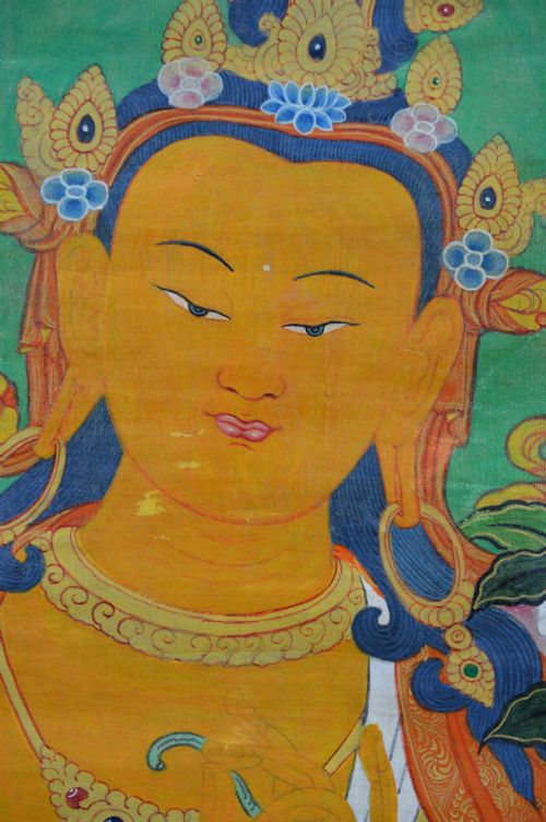 A Tibetan Thangka scroll depicting the seated deity Manjushri holding a raised sword and lotus stem, framed with a patterned silk border. View VIII
