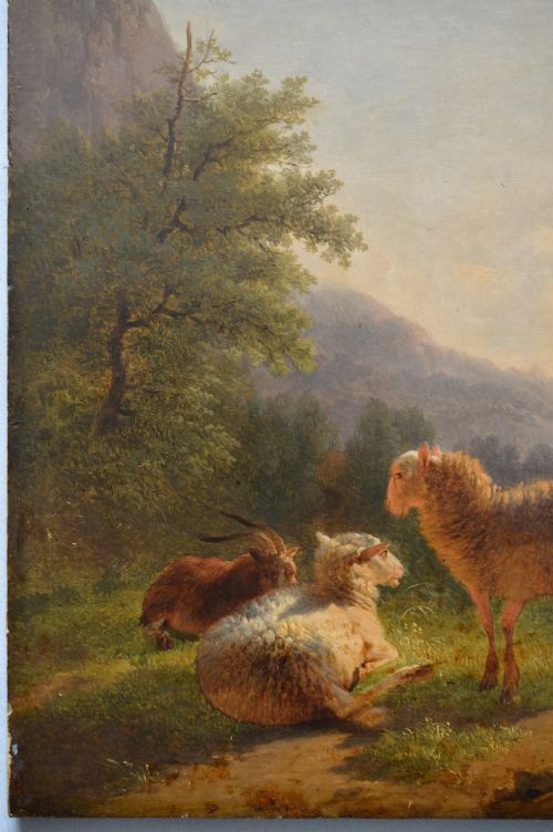 An antique oil painting depicting sheep and a goat in a green pastoral landscape surrounded by an ornate gold giltwood frame. View IX