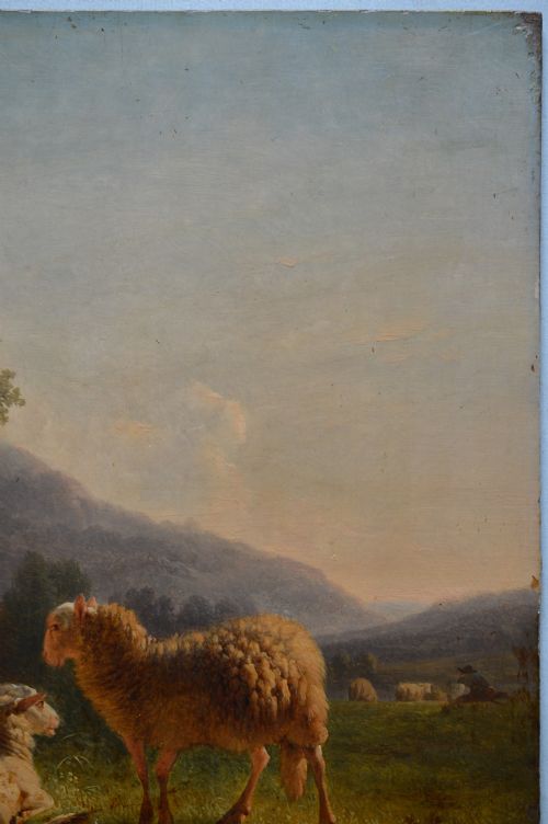 An antique oil painting depicting sheep and a goat in a green pastoral landscape surrounded by an ornate gold giltwood frame. View XI