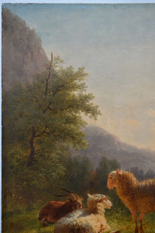 An antique oil painting depicting sheep and a goat in a green pastoral landscape surrounded by an ornate gold giltwood frame. View XII