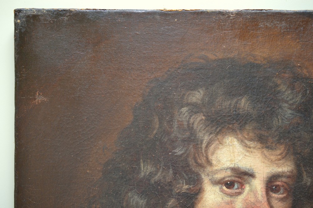 An antique oil portrait painting depicting a young gentleman with dark voluminous curls, wearing a white lace cravat and red mantle within a feigned oval frame. View VI