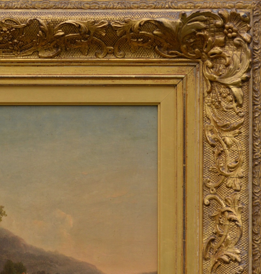 An antique oil painting depicting sheep and a goat in a green pastoral landscape surrounded by an ornate gold giltwood frame. View V