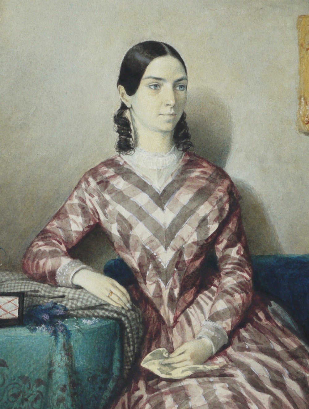 A watercolour portrait depicting a young woman in a checkered dress seated in a room beside a table covered with a teal cloth. View II