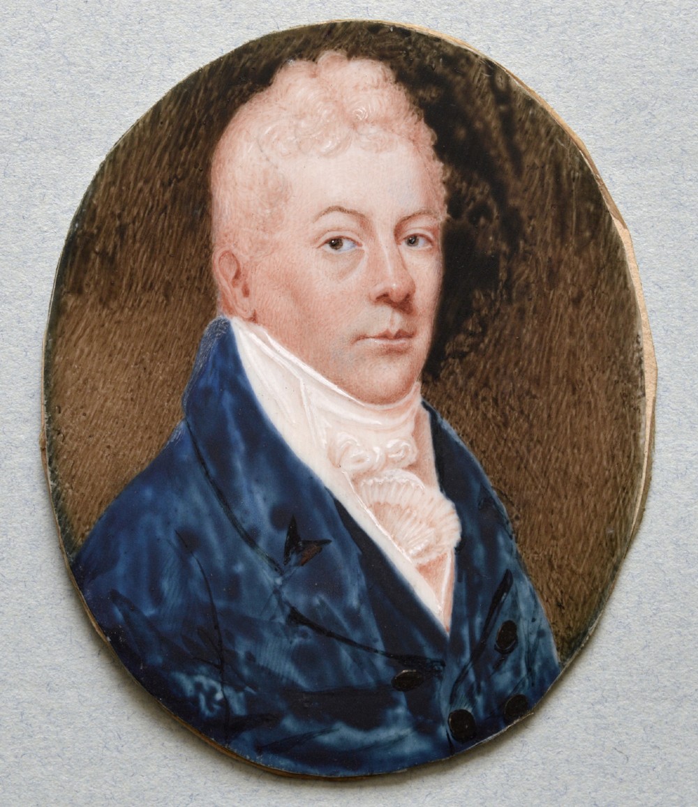 An oval late 18th-century watercolour portrait miniature depicting a gentleman wearing a blue coat and white cravat inside a metal bezel. View III