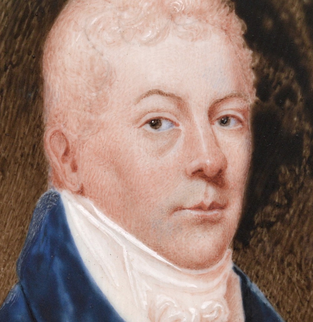 An oval late 18th-century watercolour portrait miniature depicting a gentleman wearing a blue coat and white cravat inside a metal bezel. View IV