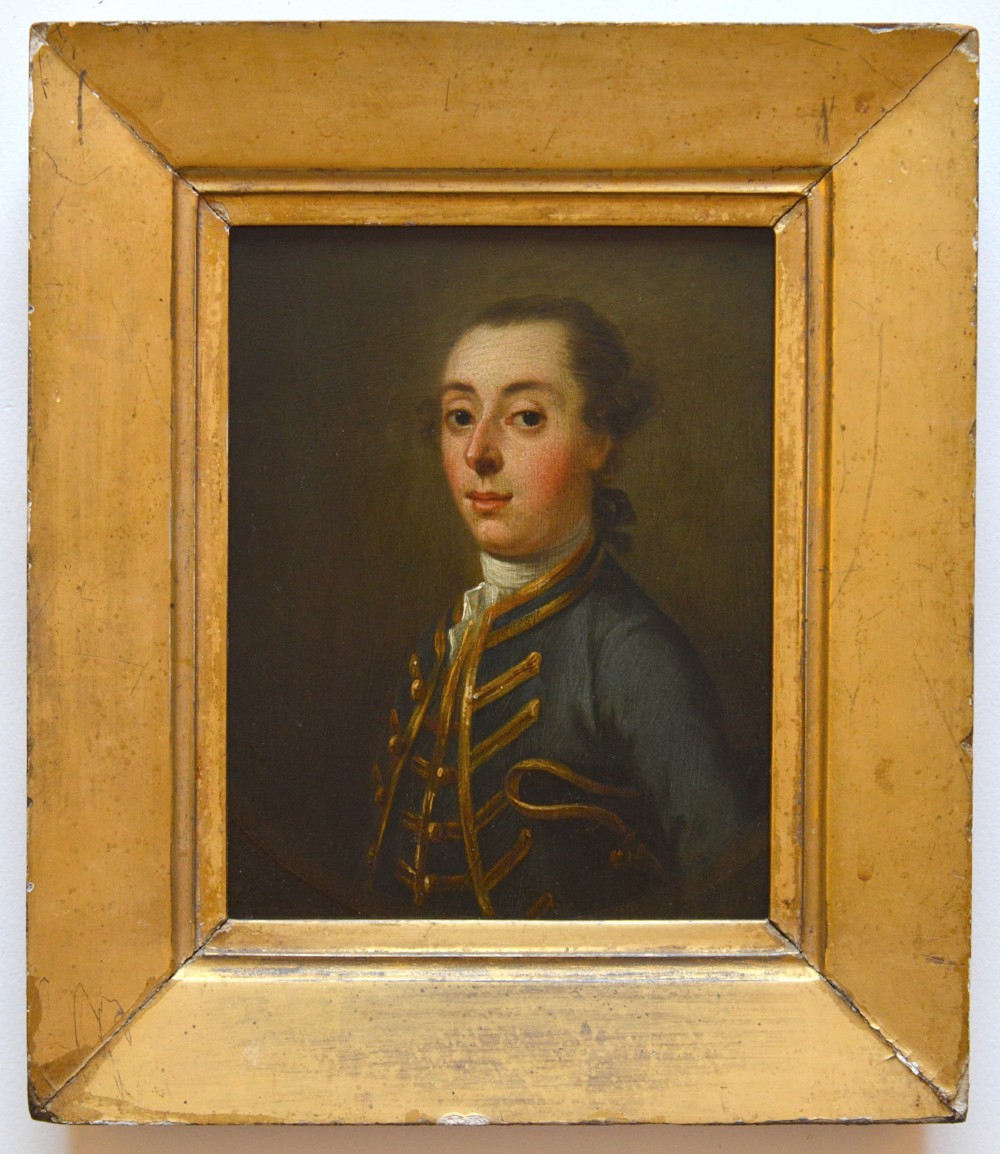 An 18th-century oil portrait depicting a gentleman in a blue military coat trimmed with gold braid, presented in a wide gilt frame.