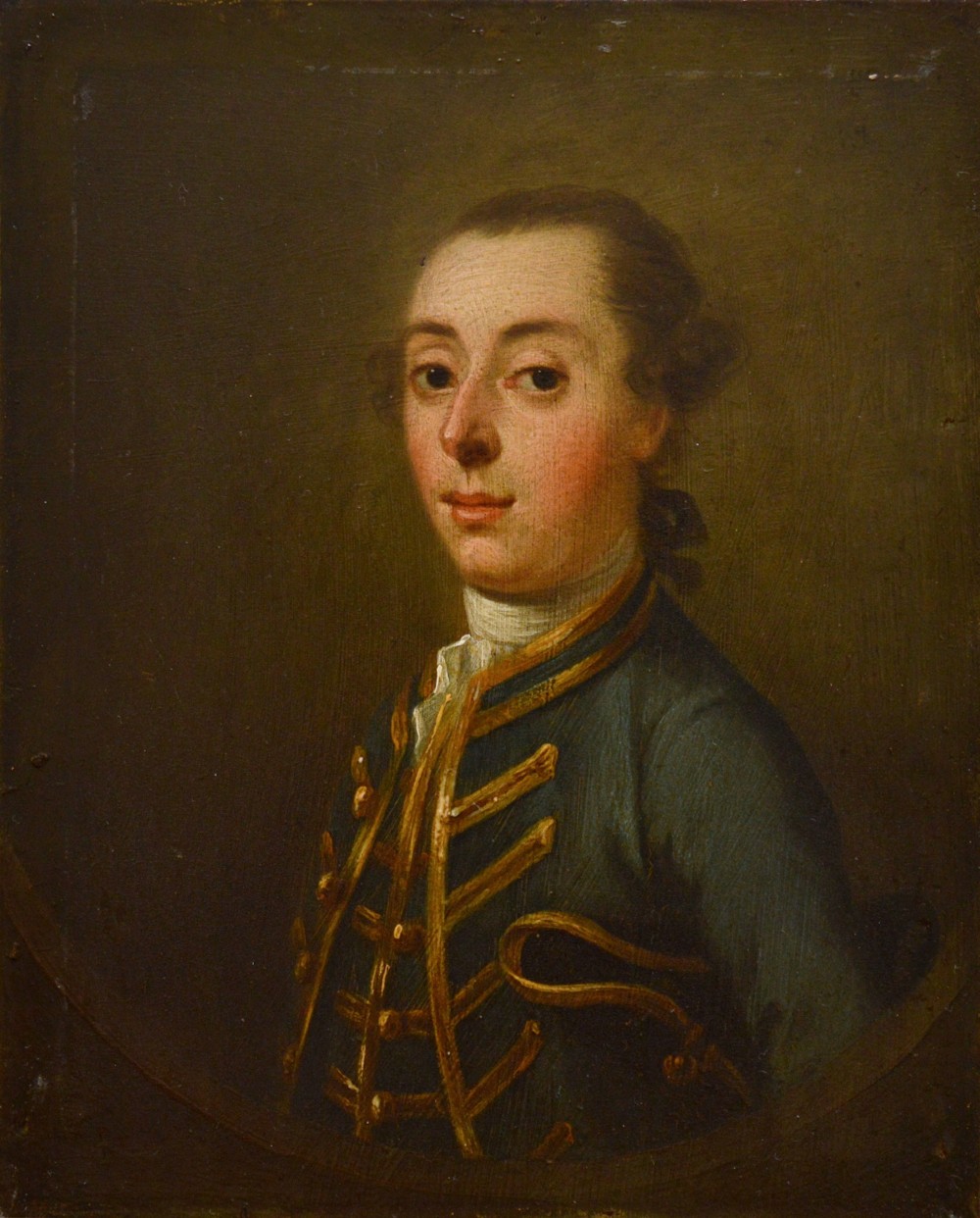 An 18th-century oil portrait depicting a gentleman in a blue military coat trimmed with gold braid, presented in a wide gilt frame. View II