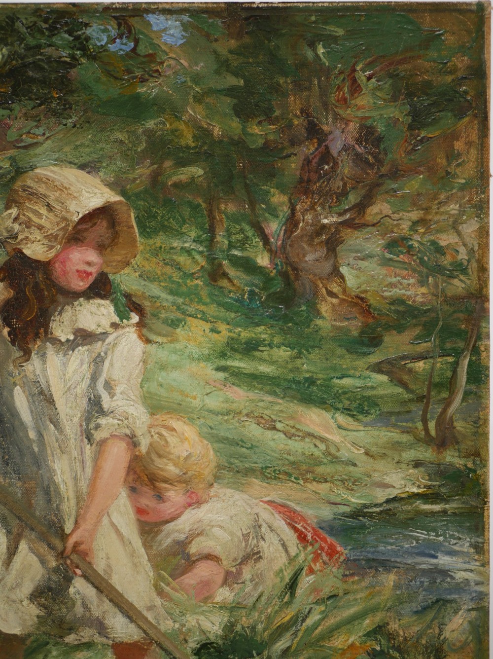 An Edwardian oil painting on board depicting three children in a green field, presented inside a moulded gold gilt frame. View V