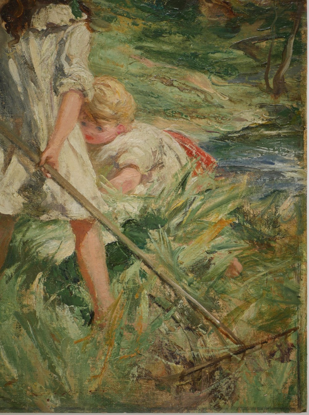 An Edwardian oil painting on board depicting three children in a green field, presented inside a moulded gold gilt frame. View VI