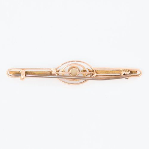 fig 2. A 9ct gold bar brooch featuring a central cabochon opal flanked by two small seed pearls within an openwork oval motif.