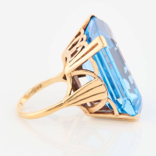 fig 2. A 9ct gold vintage dress ring featuring a large emerald-cut light blue paste stone held in a raised basket setting.
