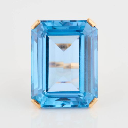 fig 3. A 9ct gold vintage dress ring featuring a large emerald-cut light blue paste stone held in a raised basket setting.