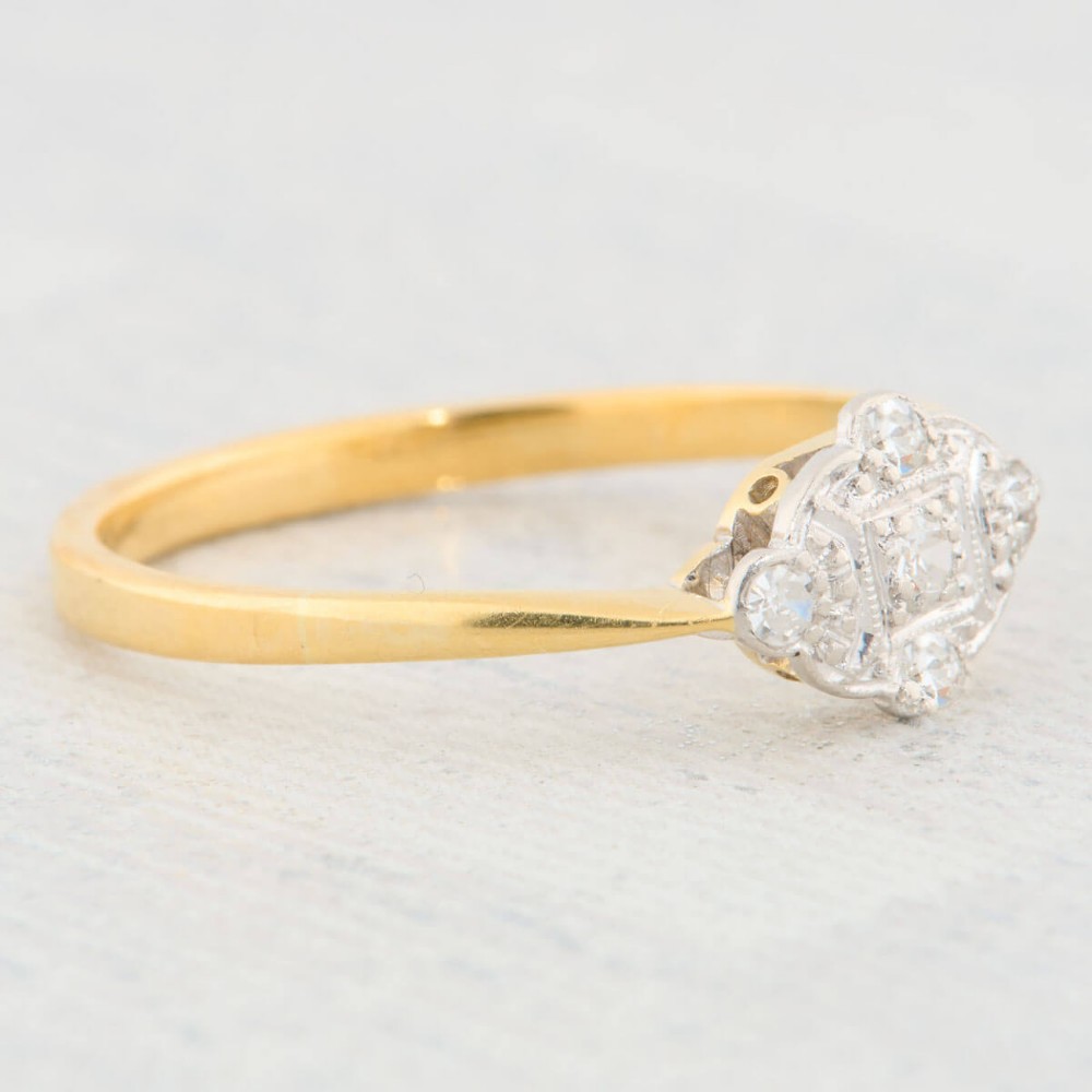 An 18ct yellow gold band featuring an Art Deco style geometric plaque set with diamonds and trimmed with millegrain edging. View IV