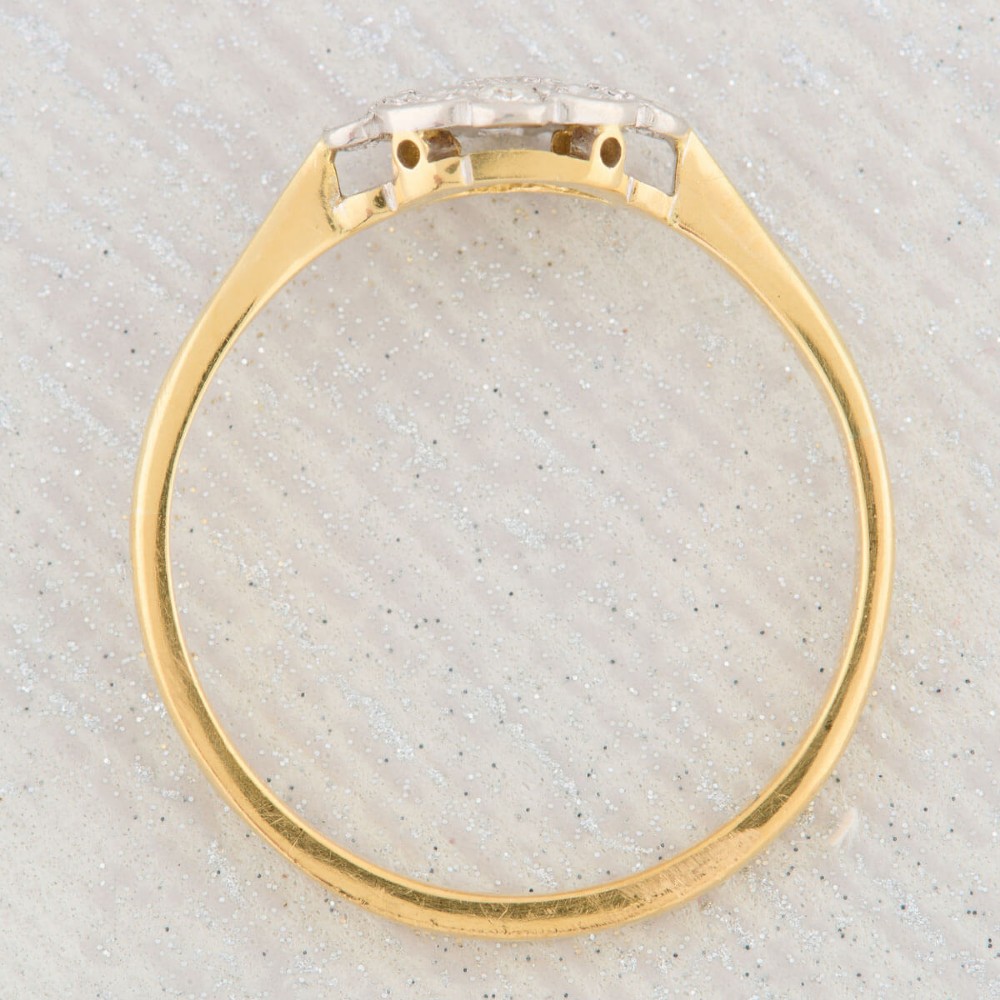 An 18ct yellow gold band featuring an Art Deco style geometric plaque set with diamonds and trimmed with millegrain edging. View VI