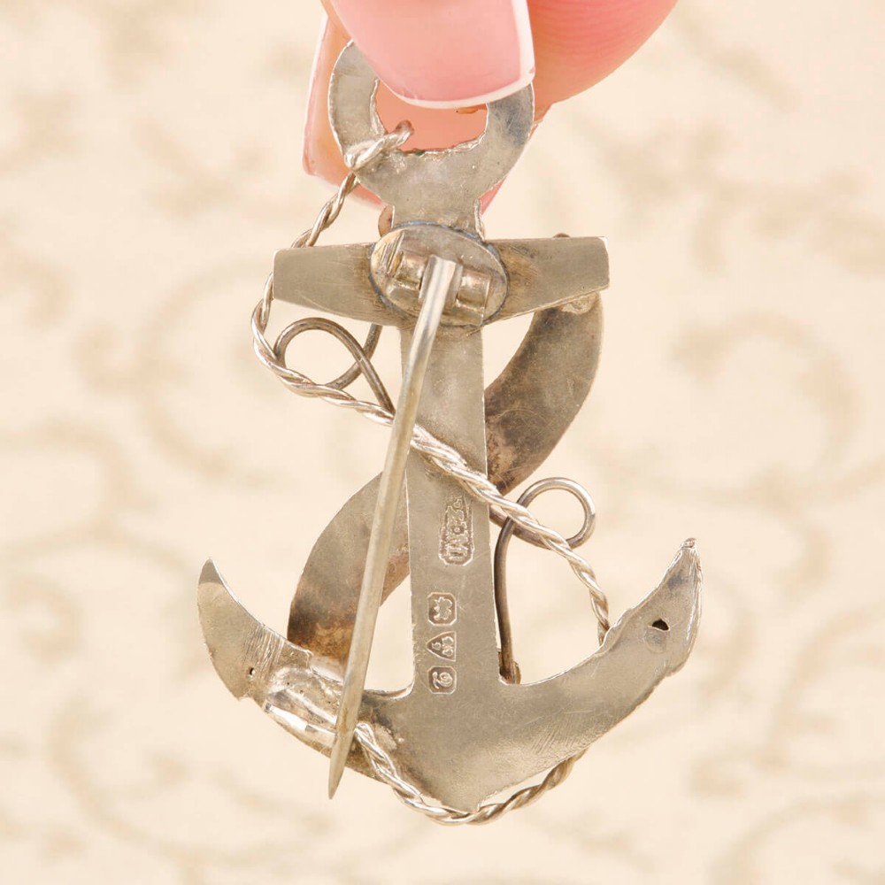An antique silver anchor brooch featuring coiled rope wirework, two rose gold flowers, and a blank central rose gold scroll banner. View III