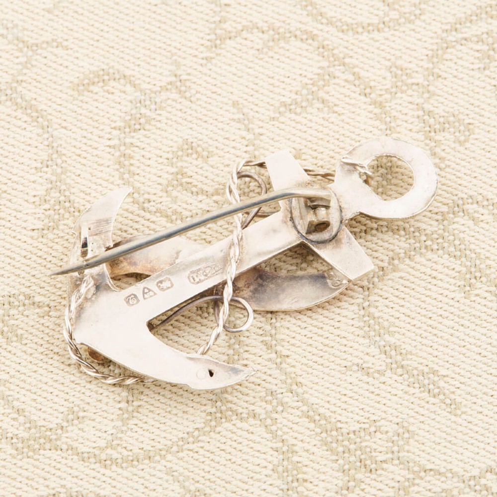 An antique silver anchor brooch featuring coiled rope wirework, two rose gold flowers, and a blank central rose gold scroll banner. View IV