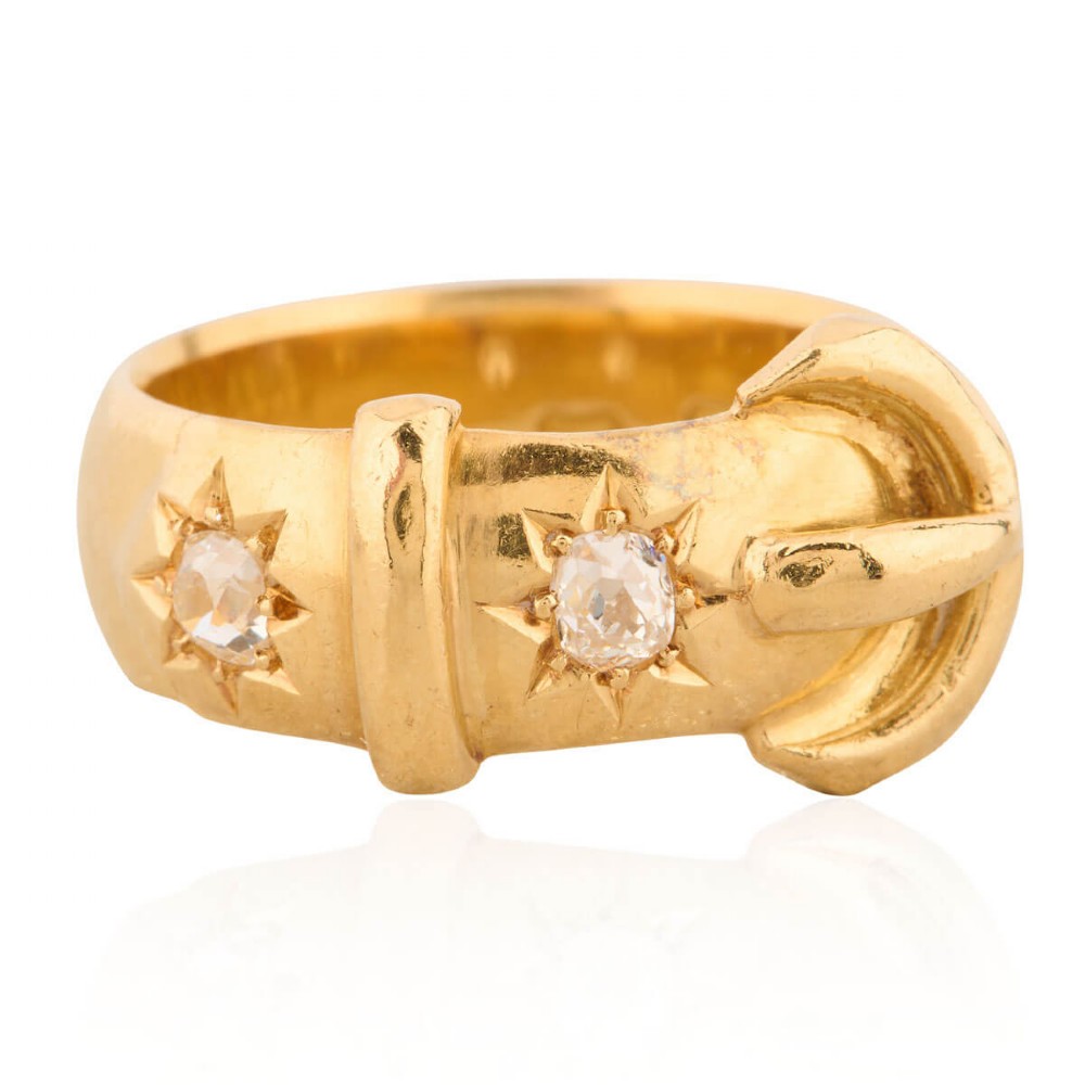 An 18ct yellow gold band shaped as a belt buckle with two star-set diamond accents.