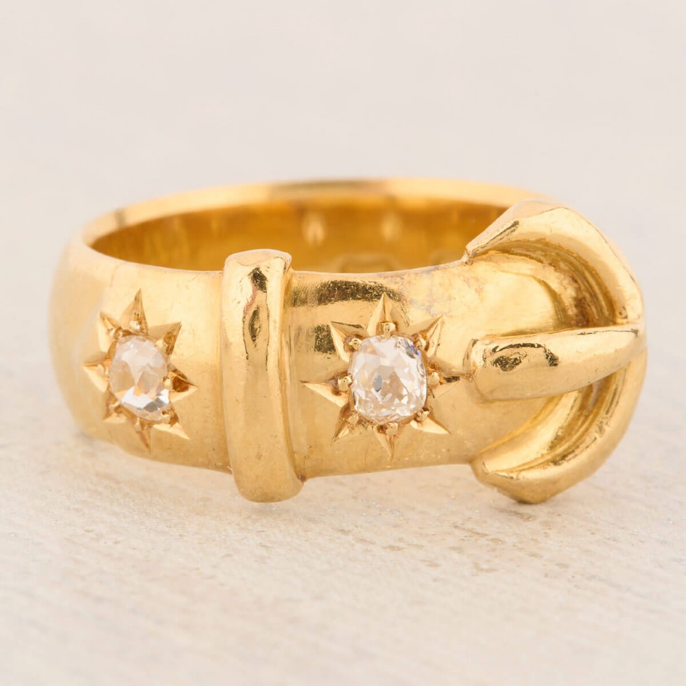 An 18ct yellow gold band shaped as a belt buckle with two star-set diamond accents. View III