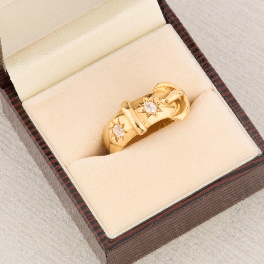 An 18ct yellow gold band shaped as a belt buckle with two star-set diamond accents. View IX