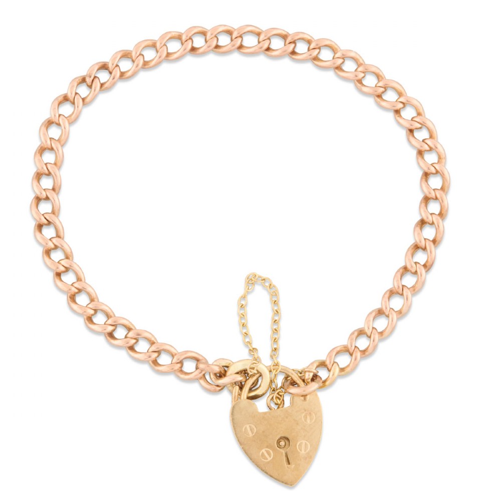 A 9ct rose gold curb chain bracelet featuring a heart-shaped padlock clasp with an attached safety chain.