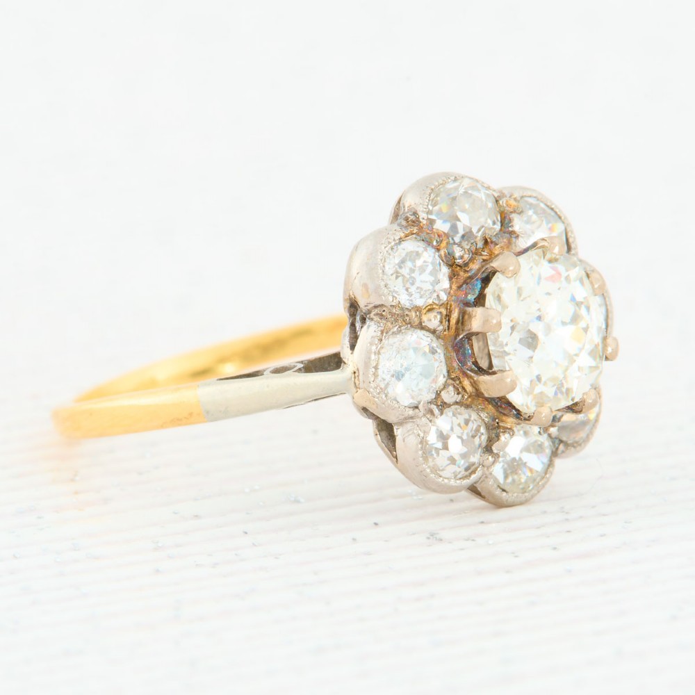 An 18ct gold ring featuring a floral-shaped cluster of round diamonds set in a platinum head. View III