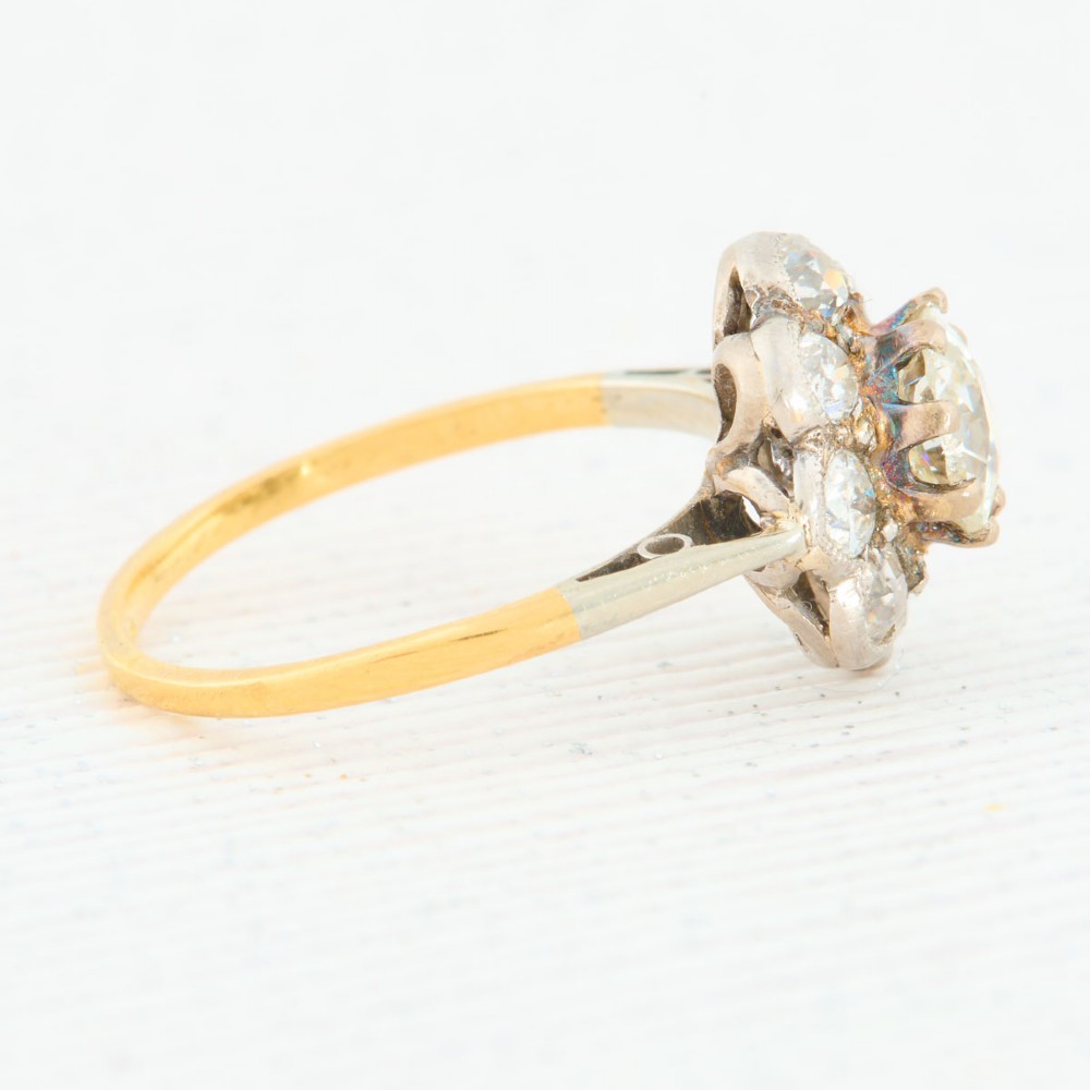 An 18ct gold ring featuring a floral-shaped cluster of round diamonds set in a platinum head. View IV