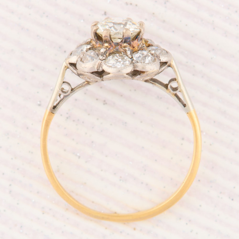 An 18ct gold ring featuring a floral-shaped cluster of round diamonds set in a platinum head. View VI
