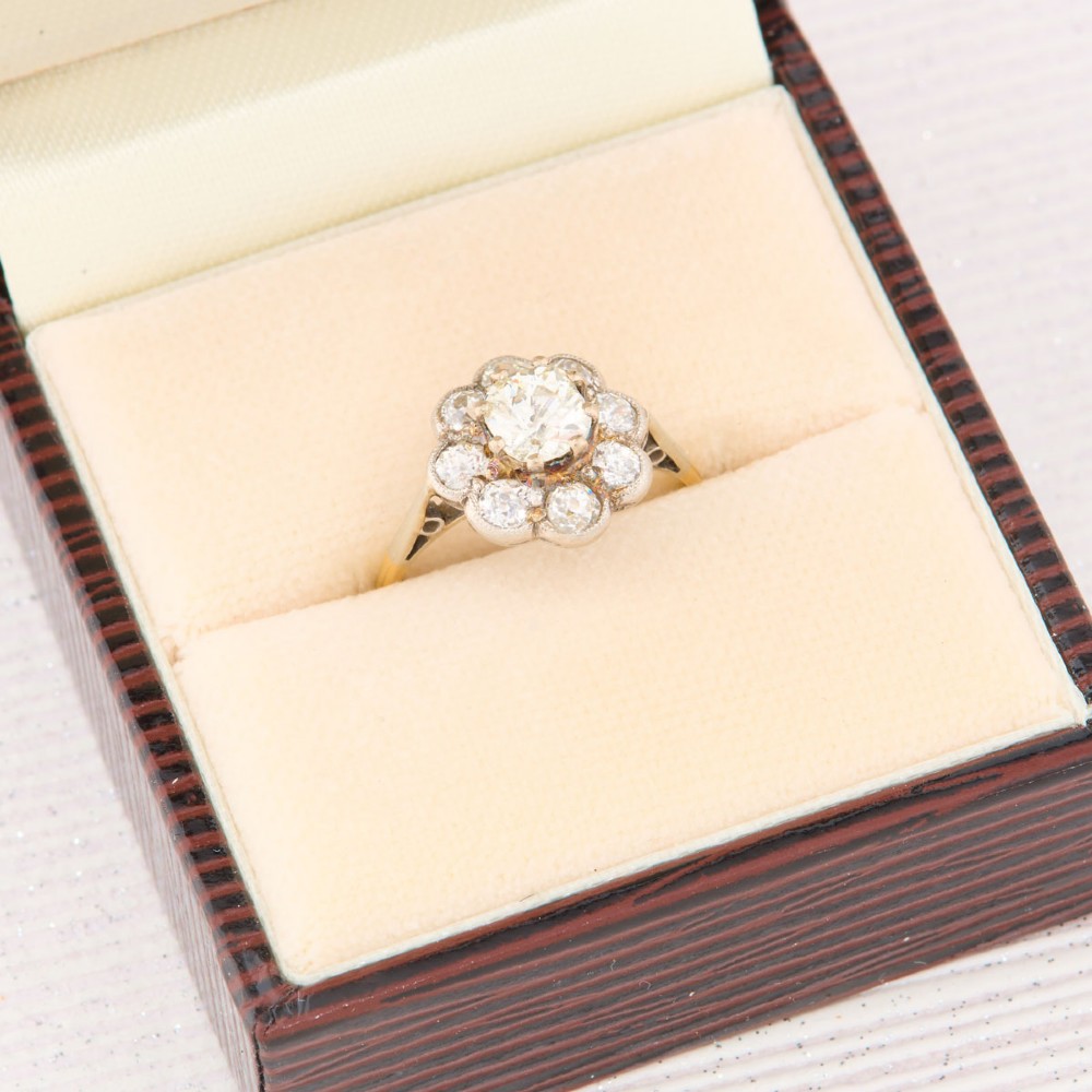 An 18ct gold ring featuring a floral-shaped cluster of round diamonds set in a platinum head. View VII