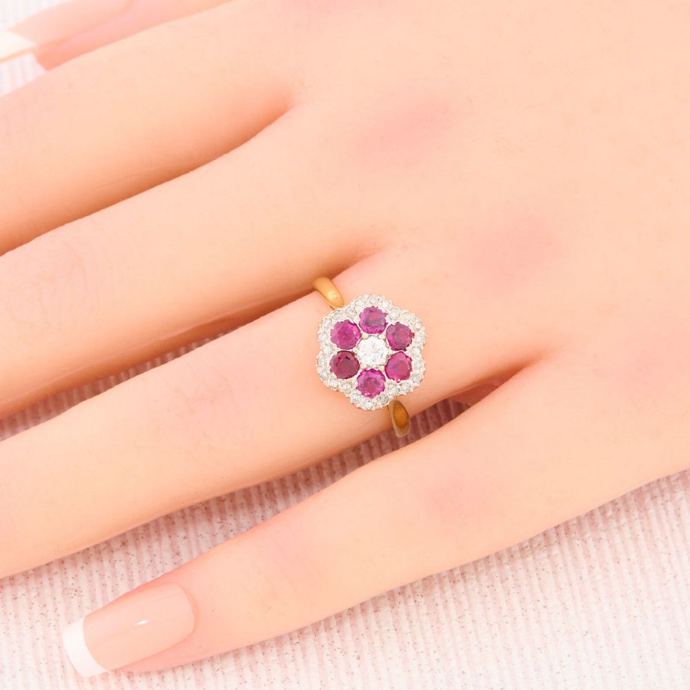 An 18ct yellow gold cluster ring with a brilliant central diamond surrounded by six round rubies and an outer diamond halo. View II