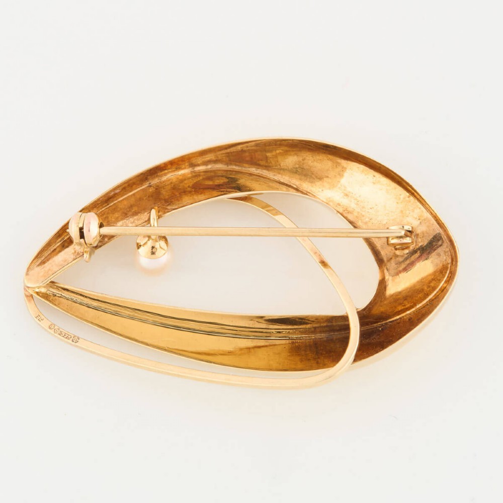 A 9ct gold brooch featuring a sweeping, abstract curved frame holding a single white pearl at its centre. View IV