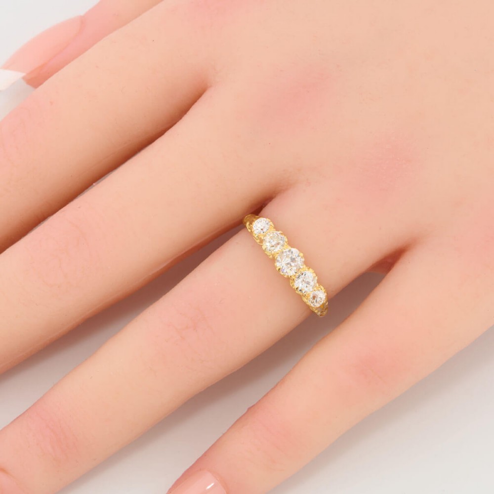 An 18ct yellow gold five-stone ring set with graduated old cut diamonds within a carved gallery. View II