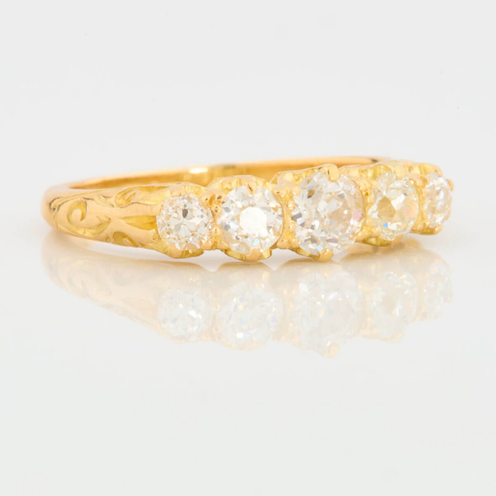 An 18ct yellow gold five-stone ring set with graduated old cut diamonds within a carved gallery. View III