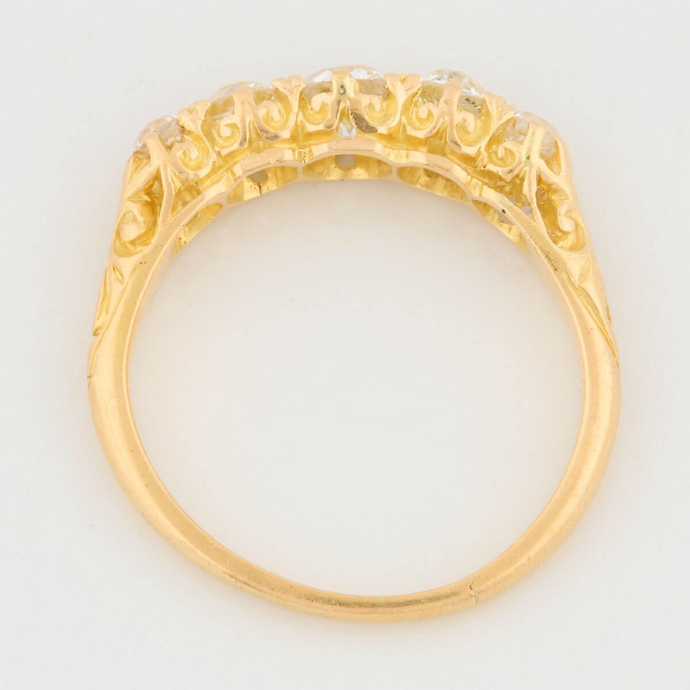 An 18ct yellow gold five-stone ring set with graduated old cut diamonds within a carved gallery. View VI