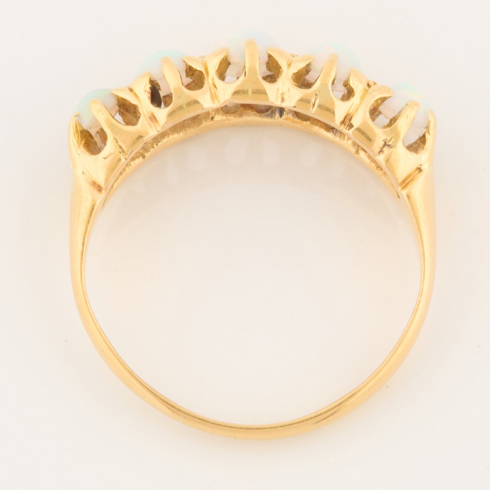 An 18ct yellow gold ring featuring five oval cabochon opals in a carved claw setting. View VI