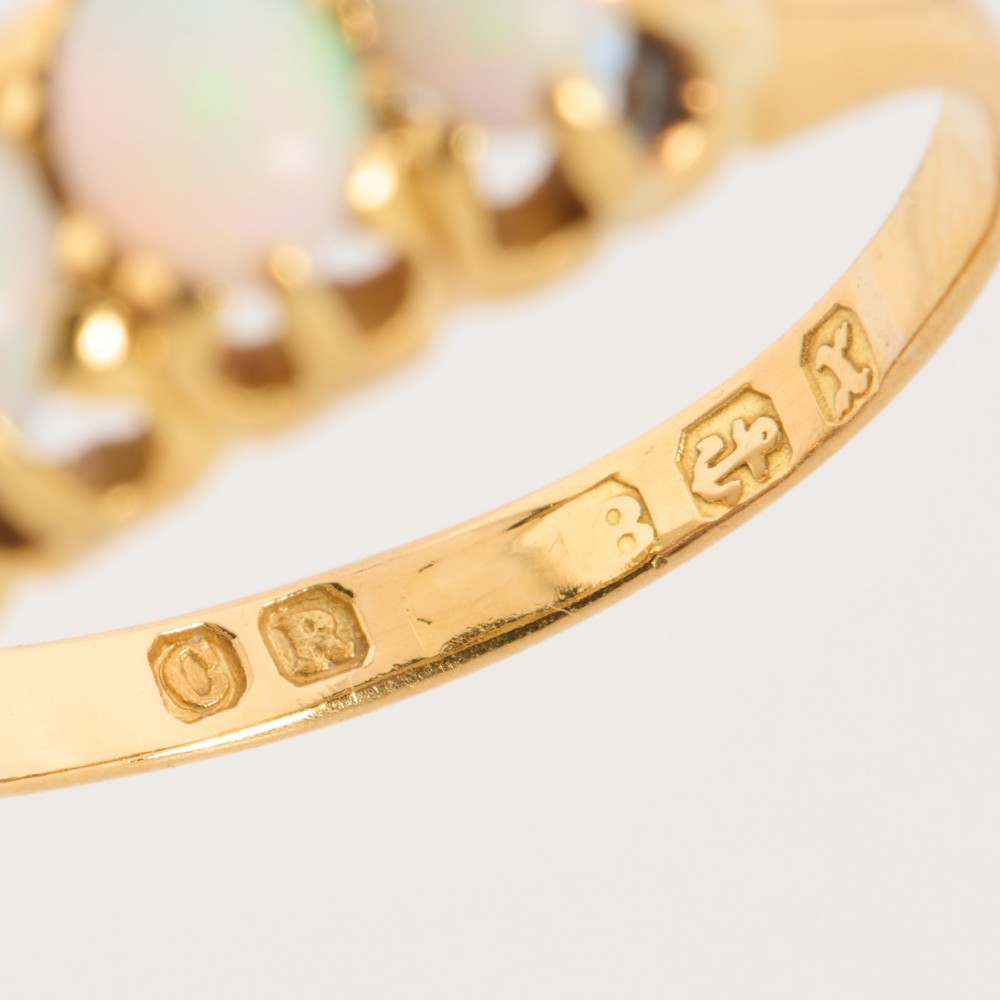 An 18ct yellow gold ring featuring five oval cabochon opals in a carved claw setting. View VII