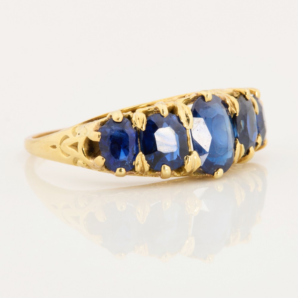 An eighteen-carat yellow gold ring featuring five graduated oval blue sapphires set in a carved claw setting. View III