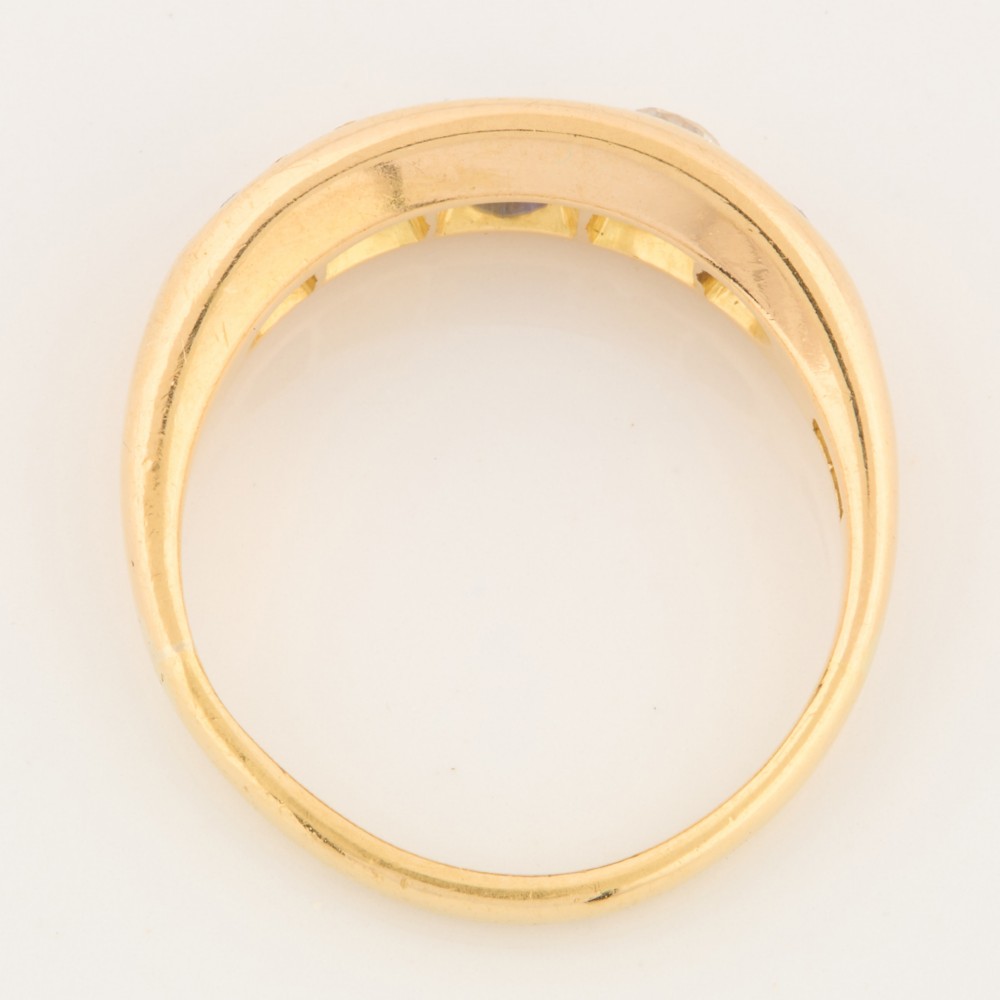An 18ct yellow gold five-stone ring featuring three round blue sapphires alternating with two round diamonds in a carved boat-style gallery. View VI