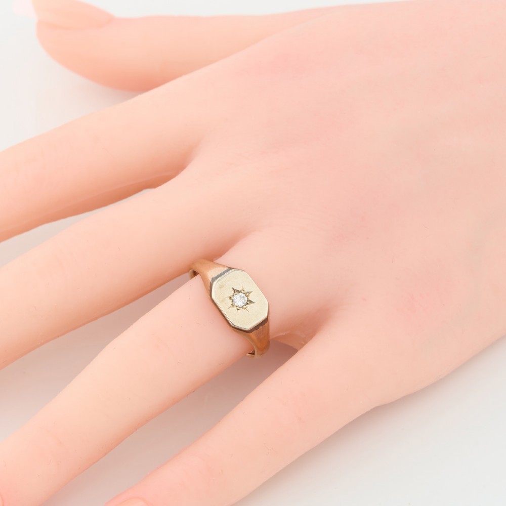 A 9ct yellow gold signet ring featuring an octagonal face with a starburst-set diamond in the centre. View II