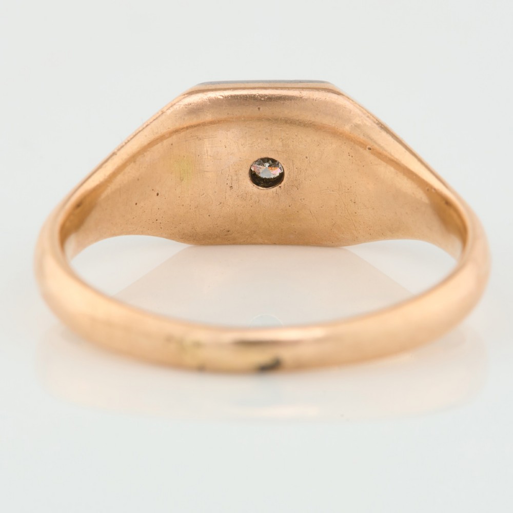 A 9ct yellow gold signet ring featuring an octagonal face with a starburst-set diamond in the centre. View IV
