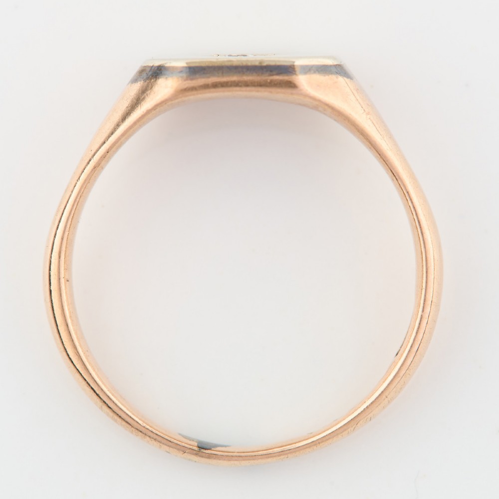 A 9ct yellow gold signet ring featuring an octagonal face with a starburst-set diamond in the centre. View V