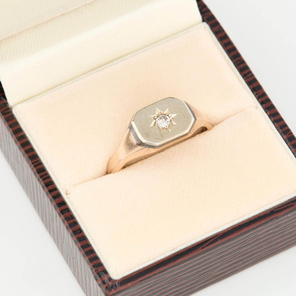 A 9ct yellow gold signet ring featuring an octagonal face with a starburst-set diamond in the centre. View VI