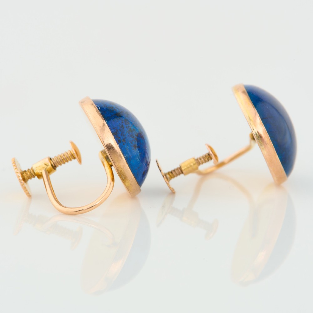A pair of round 9ct yellow gold screw-back earrings set with polished deep blue lapis lazuli cabochon gemstones. View V