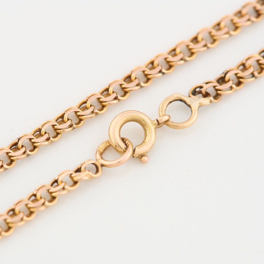A close-up view of a 9ct gold double belcher chain necklace draped against a white background. View V