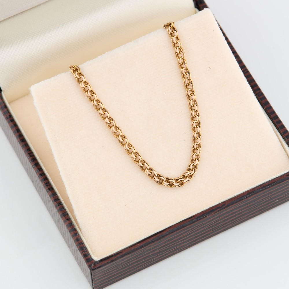 A close-up view of a 9ct gold double belcher chain necklace draped against a white background. View VI
