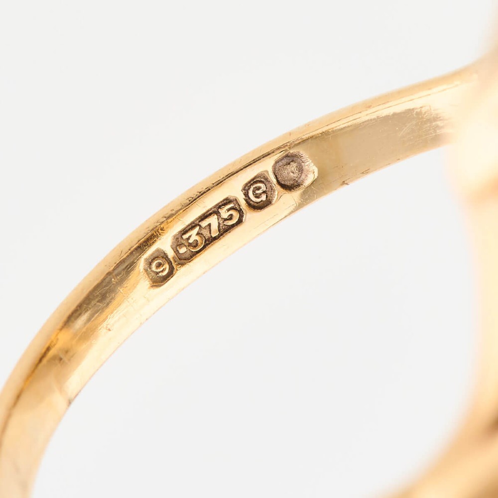 A 9ct gold vintage dress ring featuring a large emerald-cut light blue paste stone held in a raised basket setting. View VI