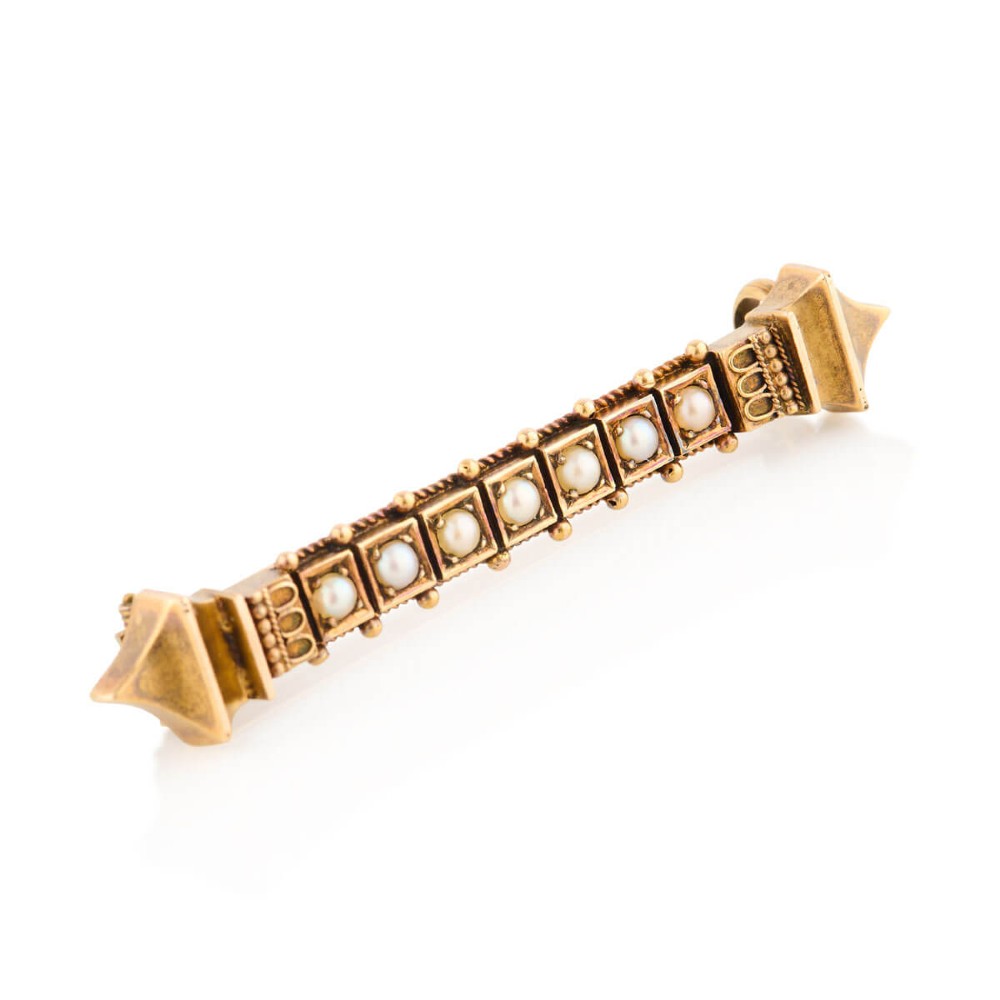 An 18ct yellow gold bar brooch decorated with a row of pearls, beaded borders, and architectural finials.