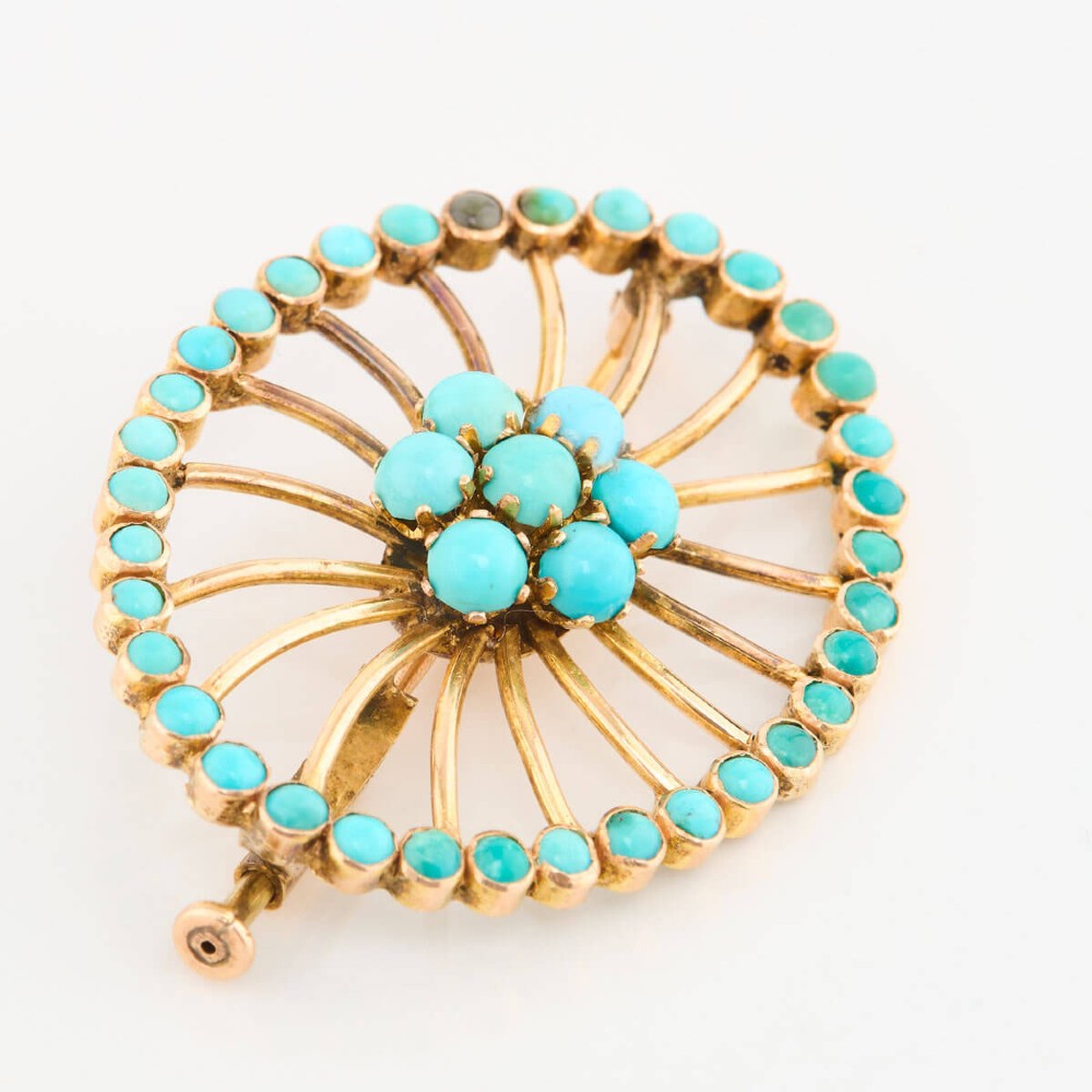 An oval openwork 14ct yellow gold brooch featuring a central floral turquoise cluster, radiating spokes, and a perimeter border set with round turquoise cabochons. View IV