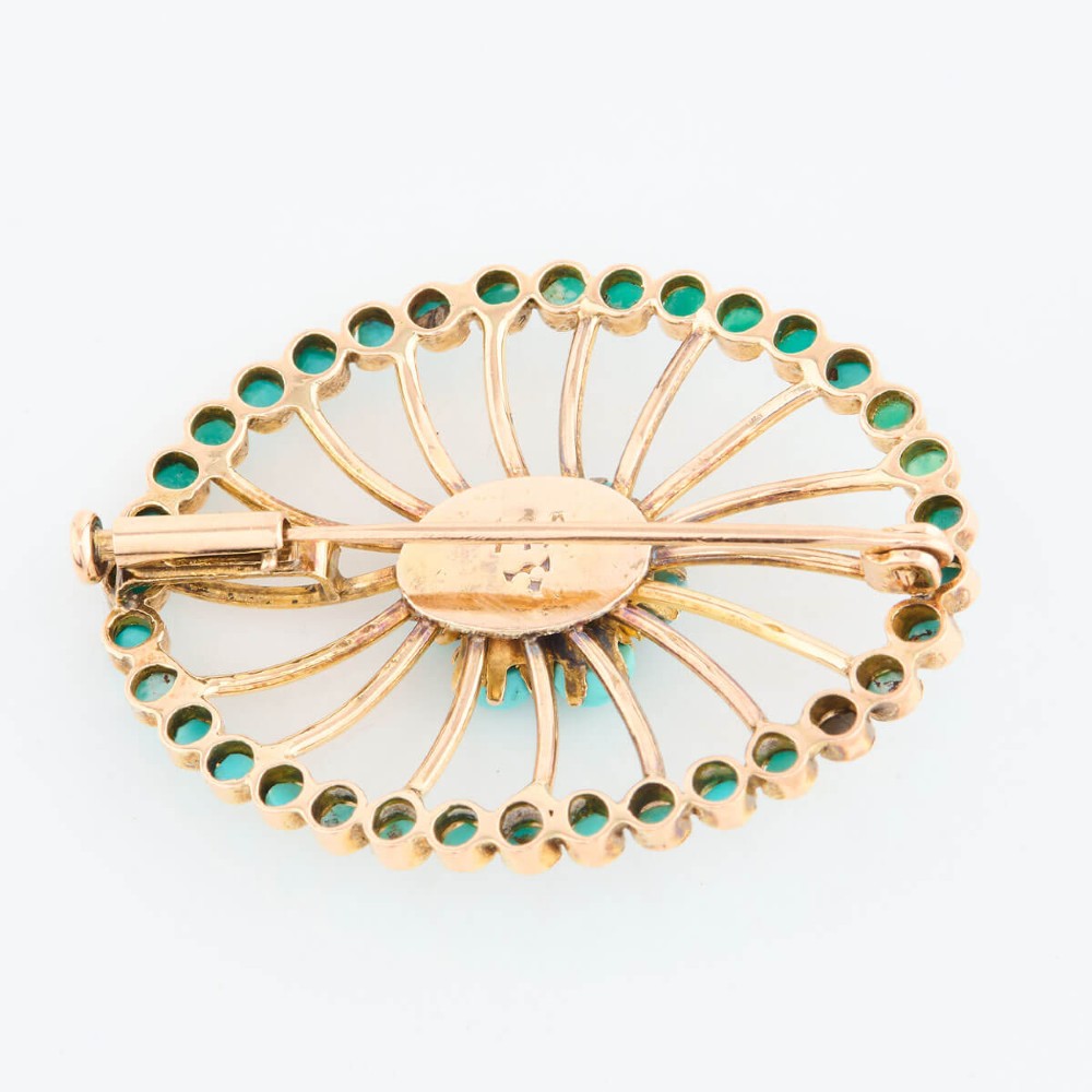 An oval openwork 14ct yellow gold brooch featuring a central floral turquoise cluster, radiating spokes, and a perimeter border set with round turquoise cabochons. View VI