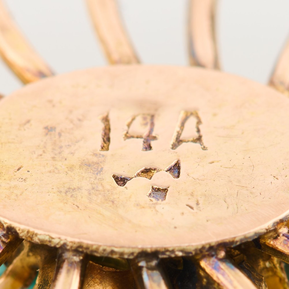 An oval openwork 14ct yellow gold brooch featuring a central floral turquoise cluster, radiating spokes, and a perimeter border set with round turquoise cabochons. View VII